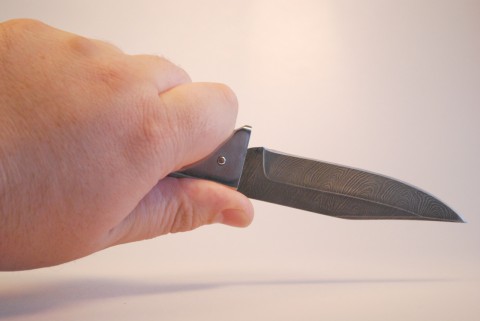 клинок ножа, удерживаемого в руке